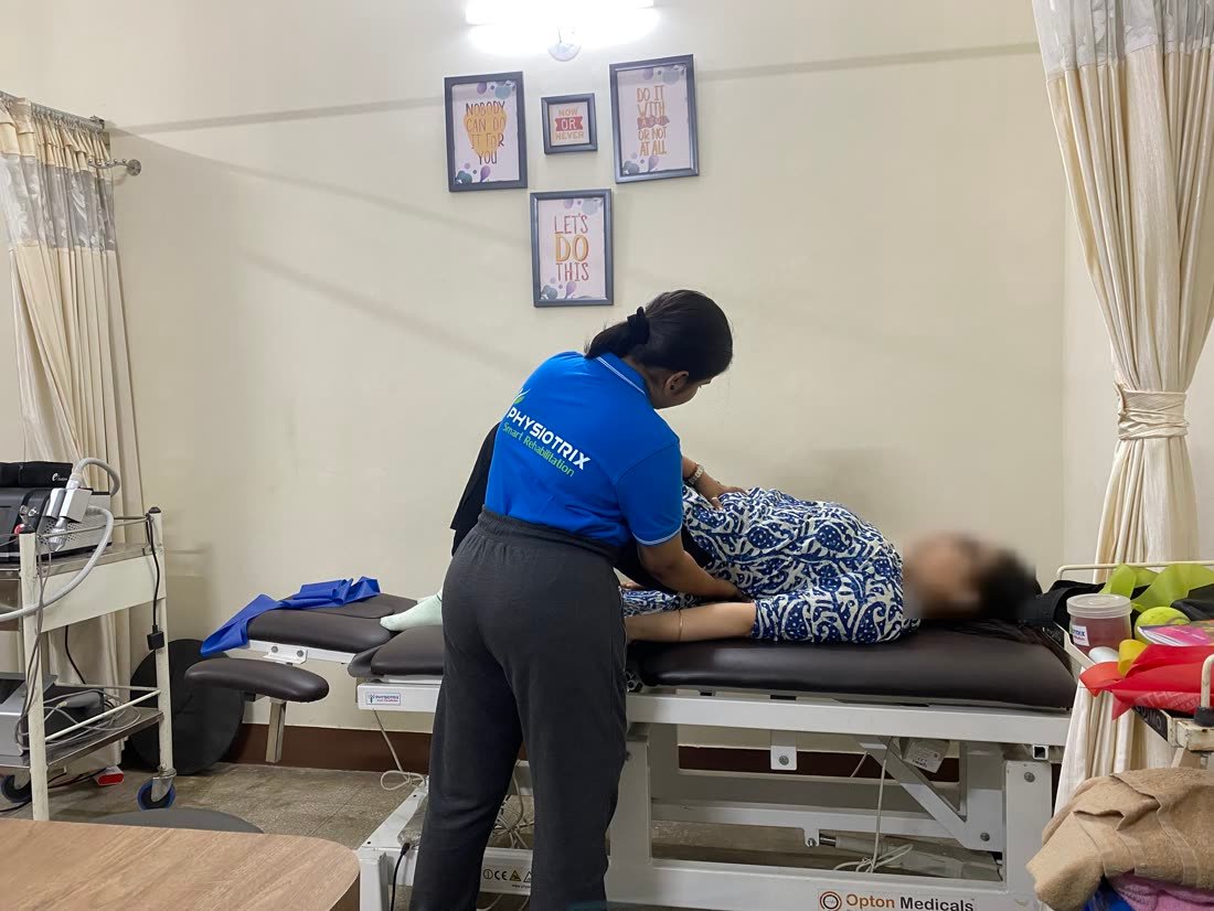 Female physiotherapist giving hands-on back treatment at Physiotrix Ballygunge